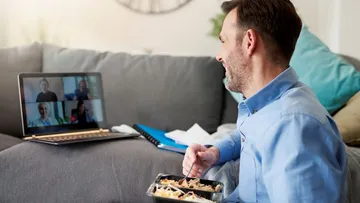 Man eating meal during video call at home.