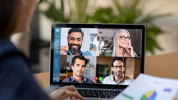 Videokonferenz mit vier anderen Personen auf einem Laptop.