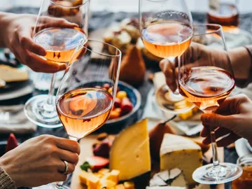 Gläser mit Roséwein werden beim Feiern angestoßen.