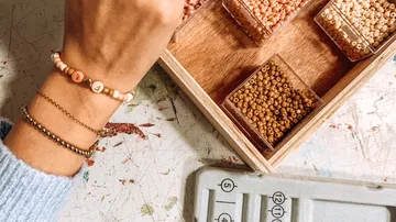 Arm wearing bracelets near bead organizer