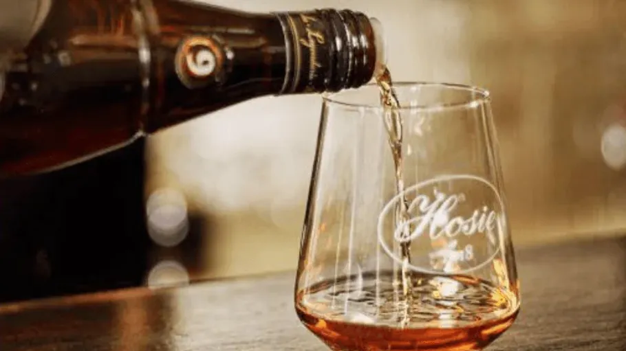 Whiskey in ein Markenglas auf dem Tisch gießen.