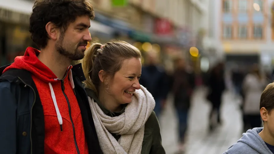 Smiling couple walking in busy street.