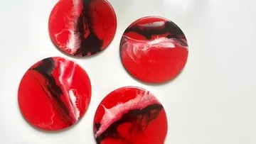 Four red and black round coasters.