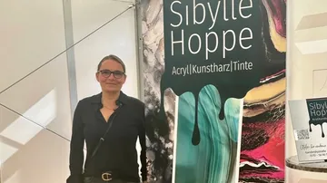 Person standing beside colorful art exhibition display.