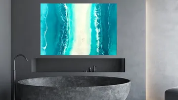 Modern bathroom with ocean artwork and stone tub.