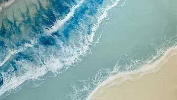 Abstrakte Meereswellen treffen auf sandige Küste.
