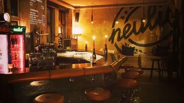Gemütliche Bar mit Hockern und gedämpfter Beleuchtung.