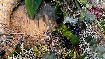 Blumenkranz aus verschiedenen Grünpflanzen und Beeren.