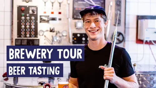 Lächelnder Mann in der Brauerei mit Metallwerkzeug.