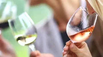 People tasting wine with glasses outdoors.