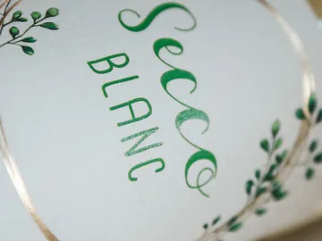 Secco Blanc-Etikett mit grünem Blumenmuster.