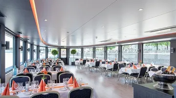 Elegant restaurant with tables, the light reflects water.