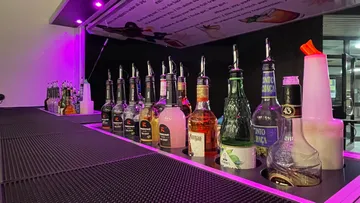 Liquor bottles lined up on a bar counter.
