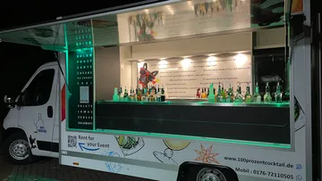 Mobile cocktail bar truck with illuminated drinks display.
