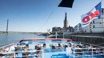 Ship covers with tables, view of city and river.