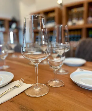 Wine glasses on wooden restaurant table.