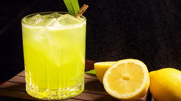 Lemon cocktail in glass with sliced lemons.