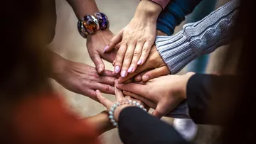 Group of hands stacked in unity.