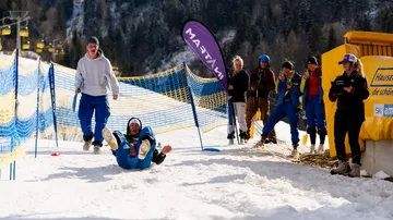 Person sliding on snow at ski event.
