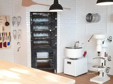A bakery with an oven, mixer and tools.