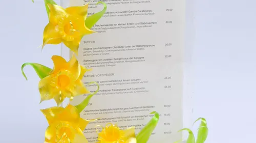 Dekorative Blumen neben einer Restaurantkarte.