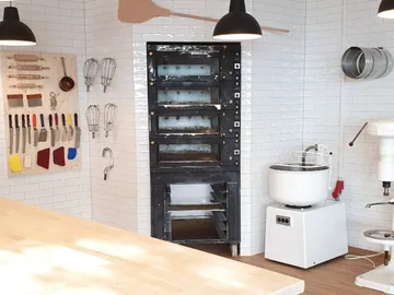 Kitchen with oven, appliances and cooking utensils on the wall.