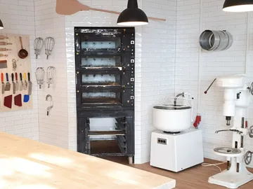 Kitchen with oven, appliances and tools on the wall.