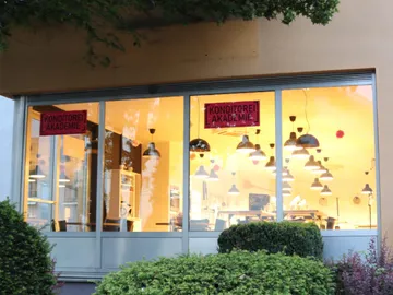 Window of a pastry shop with a bright interior.