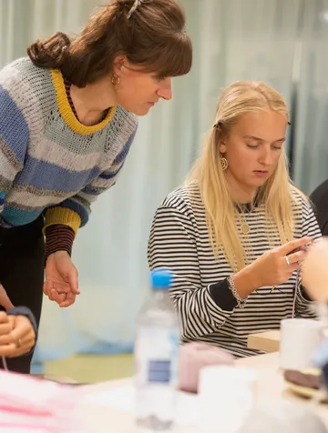 Two women knitting in a craft workshop.