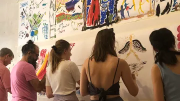 People painting on white walls indoors.