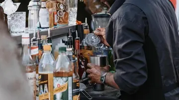Barkeeper bereitet Cocktail an der Bartheke zu.