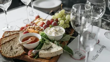 Charcuterie board with cheese, bread, fruit, and dips.