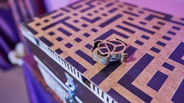 Decorative box with maze pattern and emblem.