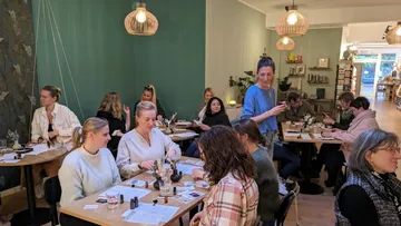 Leute basteln an Tischen in einem gemütlichen Café.