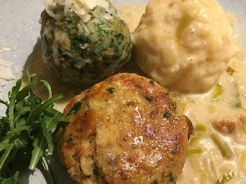Three different dumplings and a meat dish on a plate.