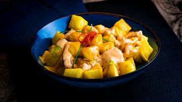 Gericht aus gewürfelten Kartoffeln mit cremiger Sauce und Kräutern.
