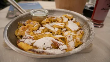 Puderzucker-Pfannkuchenstücke in einer Metallpfanne.