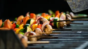 Vegetable skewers grilling on a barbecue.