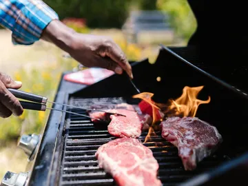 Meat is cooked on the grill; the environment is green.