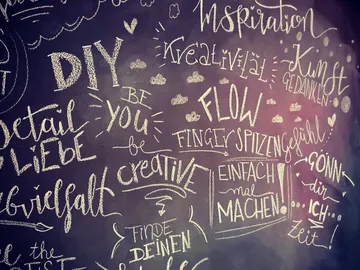 Wall with inspiring, handwritten text elements in chalk.