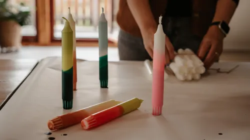 Bunte Kerzen stehen auf einer weißen Oberfläche.