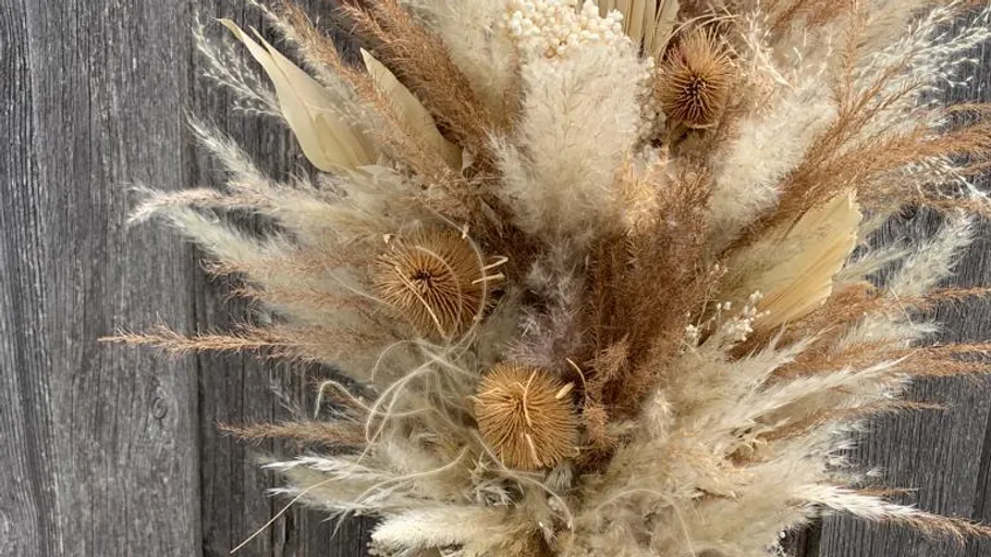 Dried flower bouquet against wooden backdrop.