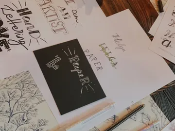 Paper with hand-drawn lettering on a table.