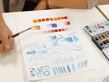 Brush paints various watercolor patterns on paper.