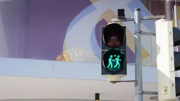 Traffic light with two figures holding hearts