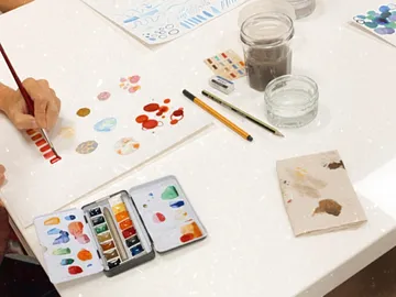 Watercolors are painted on paper in a creative environment.