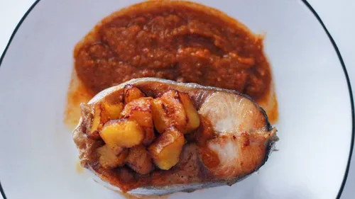 Fisch belegt mit gebratenen Kochbananen auf Sauce.