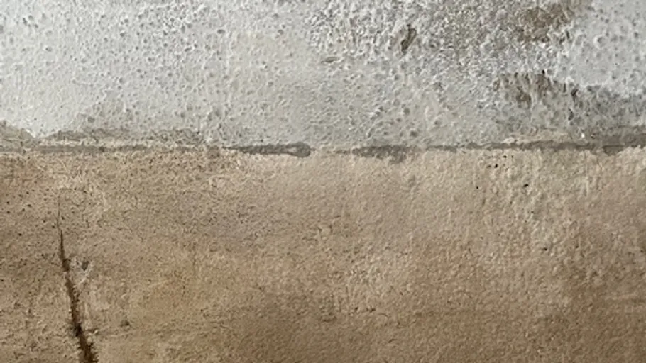 Betonwand mit Verfärbungen und Rissen