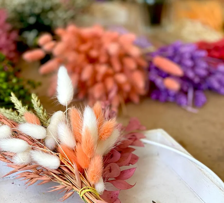 Buntes getrocknetes Blumenarrangement auf dem Tisch.