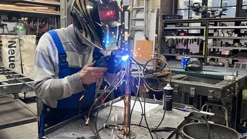Person, die Metall in der Werkstatt schweißt.
